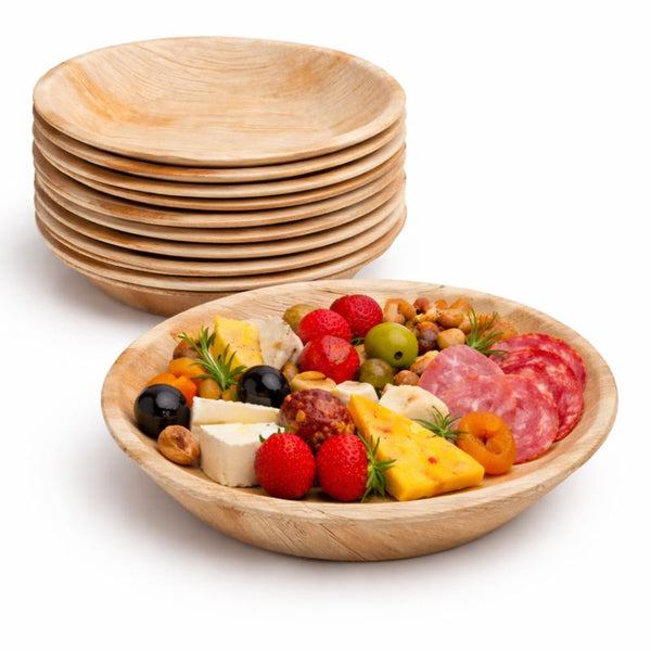 Stack of wooden bowls with a smaller bowl containing fruits, cheese, and meats on a white background